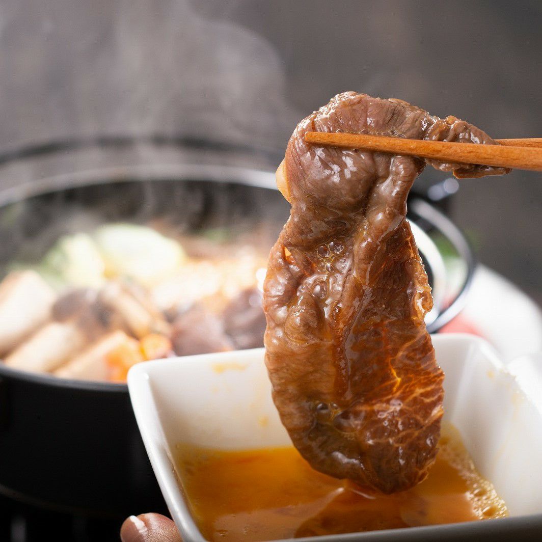 松阪牛のすき焼き肉に生卵を付けて食べる前